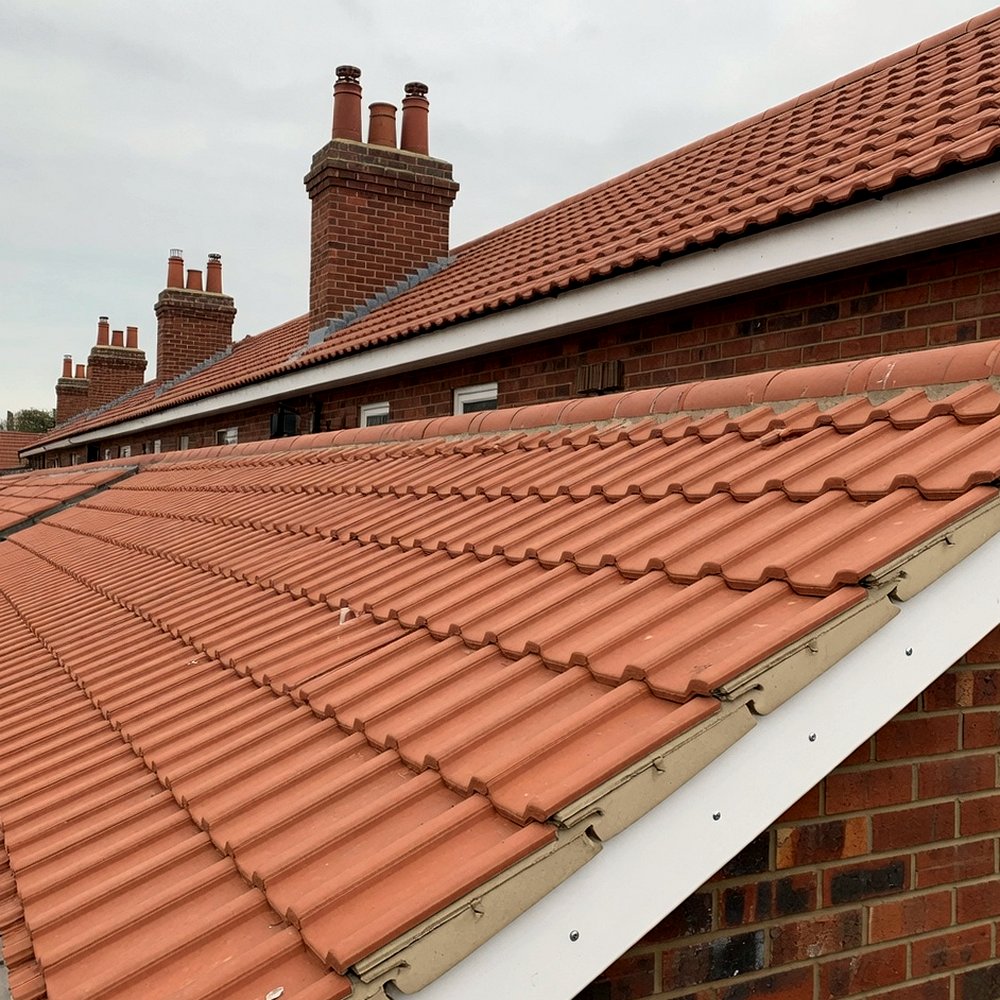 Clay pantile roofs along a brick terrace with white fascia